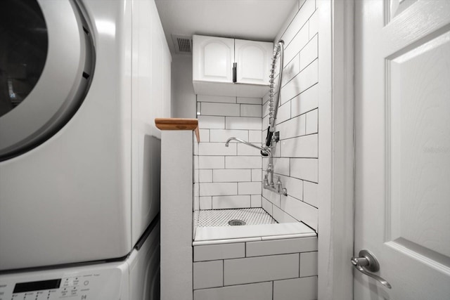 clothes washing area featuring stacked washer and dryer