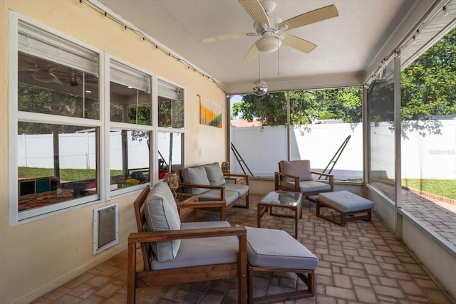 sunroom / solarium featuring ceiling fan and plenty of natural light