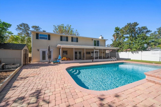 view of pool with a storage shed, a patio, and french doors