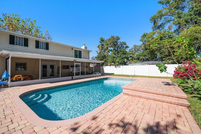 view of pool featuring french doors, a patio, and a sunroom