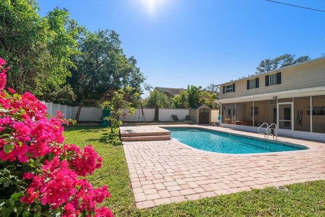 view of swimming pool featuring a patio area, a storage shed, and a sunroom