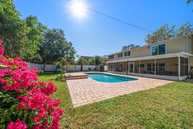 view of pool with a patio, a lawn, and a sunroom