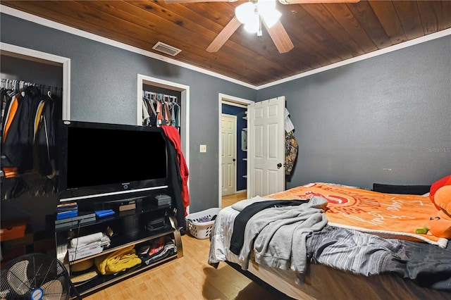 bedroom with hardwood / wood-style floors, ceiling fan, wooden ceiling, and ornamental molding