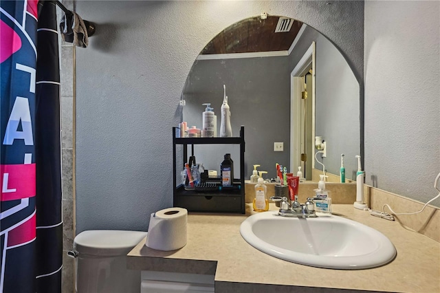 bathroom with a shower with shower curtain, vanity, and toilet