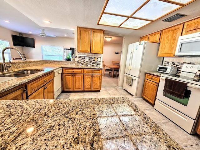 kitchen with white appliances, sink, ceiling fan, decorative backsplash, and kitchen peninsula