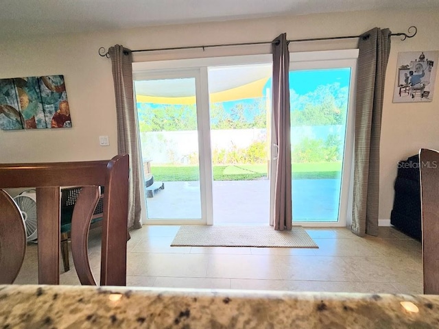 doorway to outside featuring light tile patterned floors and a healthy amount of sunlight