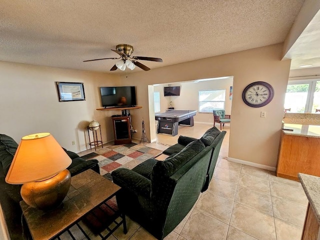 tiled living room featuring ceiling fan and a textured ceiling