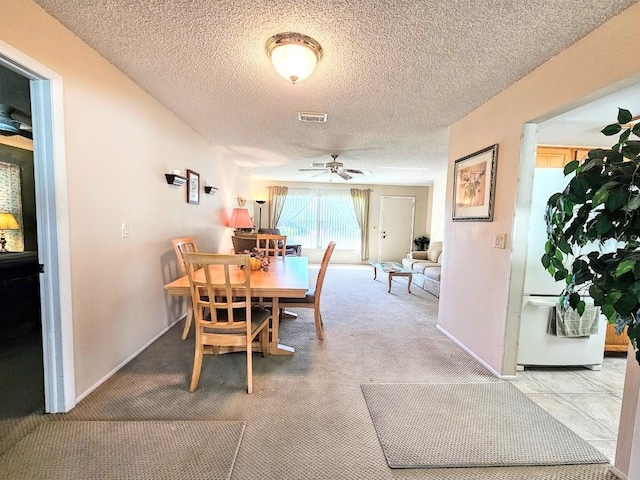 dining area featuring ceiling fan, carpet floors, and a textured ceiling