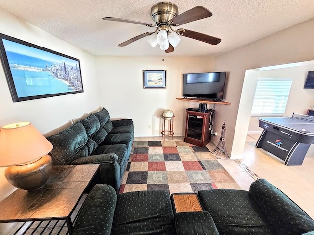 living room with ceiling fan and a textured ceiling