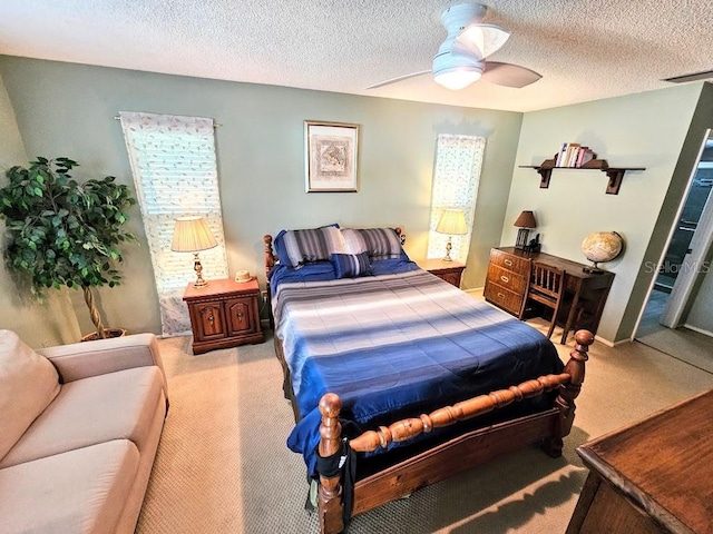 bedroom with a textured ceiling, carpet floors, and ceiling fan