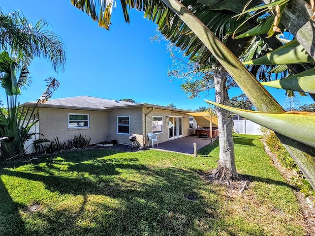 back of property with a patio area and a lawn