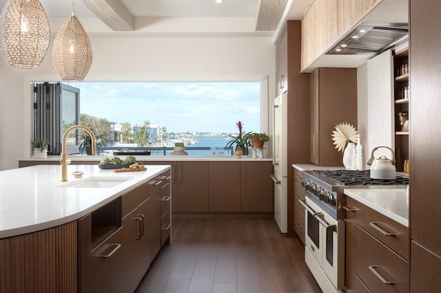 kitchen with sink, dark wood-type flooring, double oven range, a water view, and exhaust hood