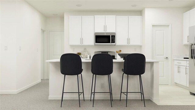 kitchen with a kitchen breakfast bar, light carpet, and white cabinets