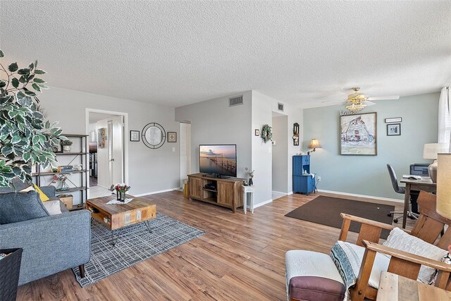 4915 Bay St NE Unit 130, Saint Petersburg, FL 33703 - living room with wood finished floors, a textured ceiling, a desk, and a ceiling fan