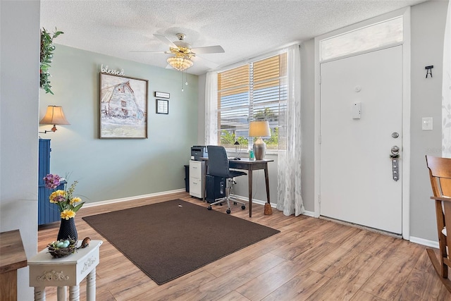 foyer featuring a textured ceiling, light hardwood / wood-style flooring, and ceiling fan