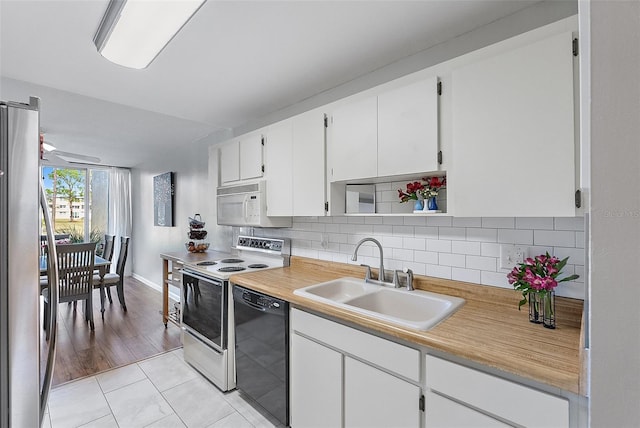 kitchen featuring white appliances, backsplash, sink, light hardwood / wood-style floors, and white cabinetry