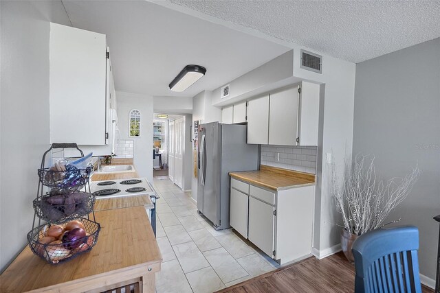 4915 Bay St NE Unit 130, Saint Petersburg, FL 33703 - kitchen featuring freestanding refrigerator, light countertops, white cabinetry, white electric range, and tasteful backsplash