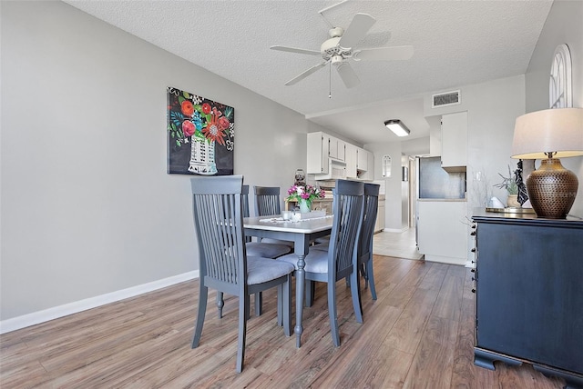4915 Bay St NE Unit 130, Saint Petersburg, FL 33703 - dining area featuring light wood-style flooring, a textured ceiling, and a ceiling fan