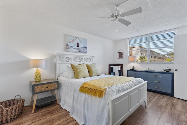 bedroom featuring ceiling fan, a textured ceiling, and hardwood / wood-style flooring