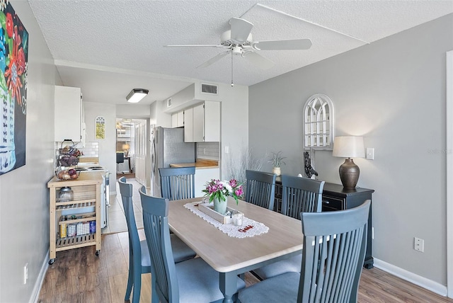 4915 Bay St NE Unit 130, Saint Petersburg, FL 33703 - dining area with ceiling fan, wood finished floors, wine cooler, and a textured ceiling