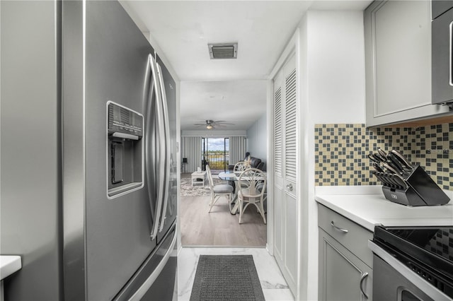 kitchen with decorative backsplash, appliances with stainless steel finishes, ceiling fan, and gray cabinetry