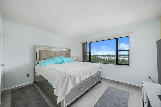 bedroom featuring a textured ceiling and light wood-type flooring