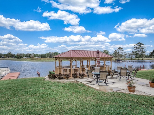 dock area with a gazebo, a water view, and a lawn