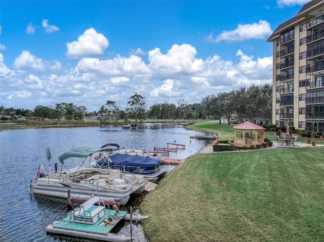 dock area with a gazebo, a yard, and a water view