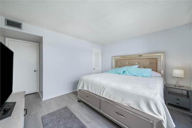 bedroom featuring a textured ceiling and light wood-type flooring