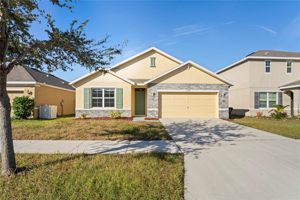 ranch-style home featuring a garage and a front lawn