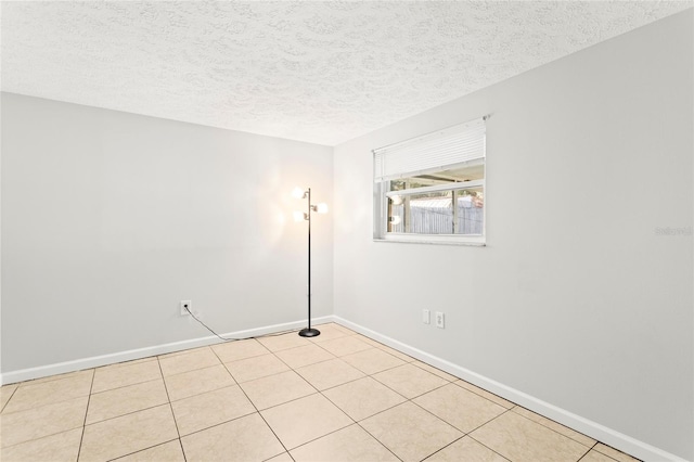 tiled spare room with a textured ceiling