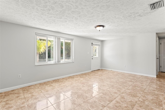 unfurnished room with light tile patterned floors and a textured ceiling