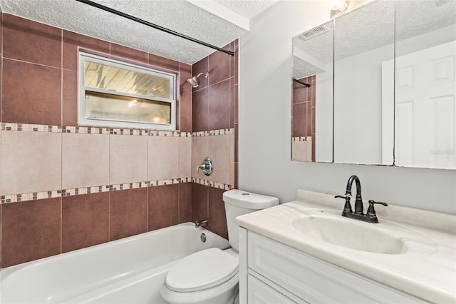 full bathroom featuring vanity, tiled shower / bath combo, a textured ceiling, and toilet