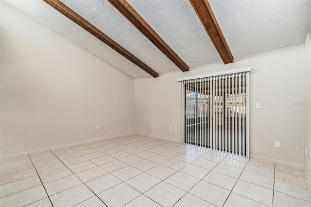 empty room featuring vaulted ceiling with beams and light tile patterned flooring