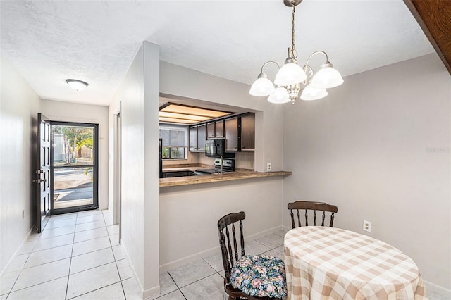 dining space featuring light tile patterned floors, a textured ceiling, and a chandelier