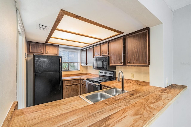 kitchen with kitchen peninsula, sink, black appliances, and wood counters