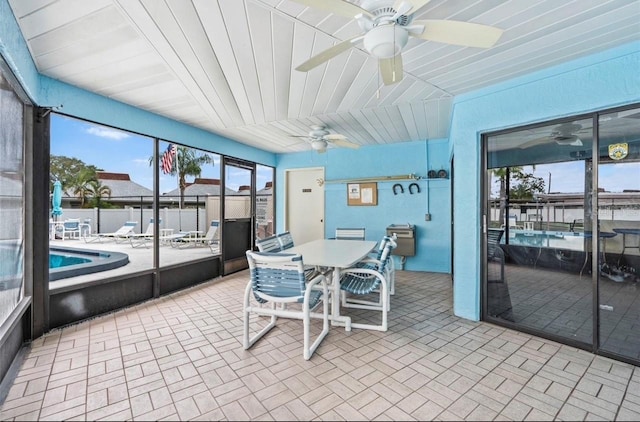 sunroom with ceiling fan and vaulted ceiling