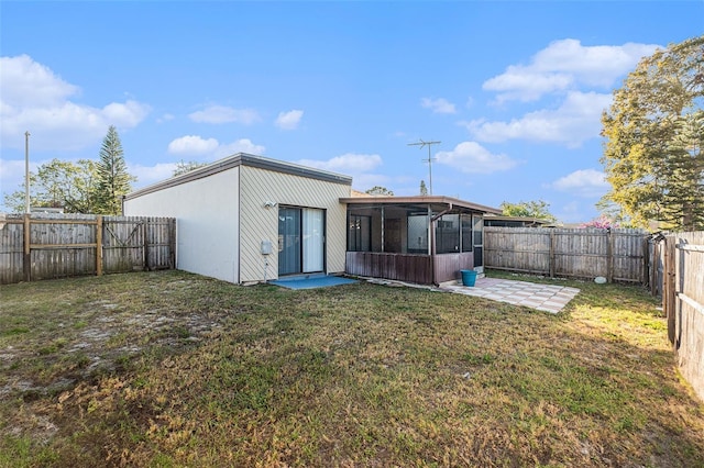 rear view of house with a sunroom and a yard