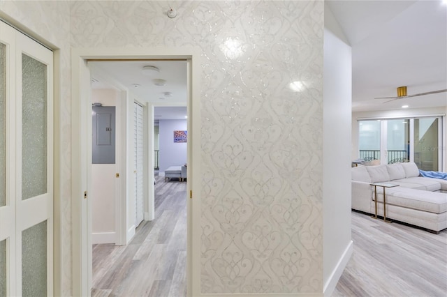 hallway with light hardwood / wood-style floors and electric panel