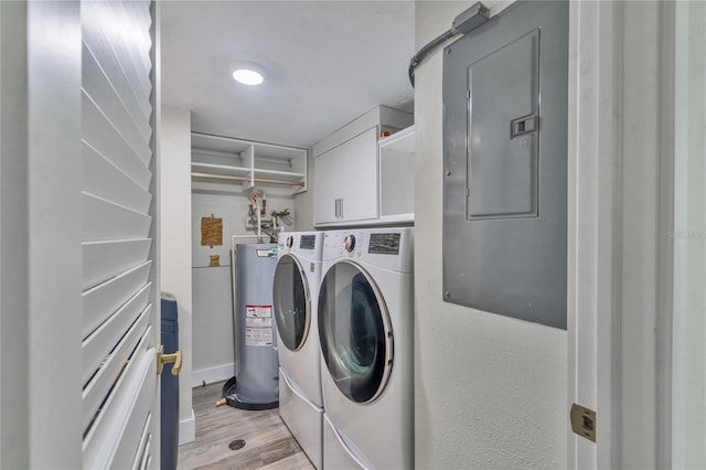 laundry room with water heater, cabinets, light hardwood / wood-style floors, independent washer and dryer, and electric panel