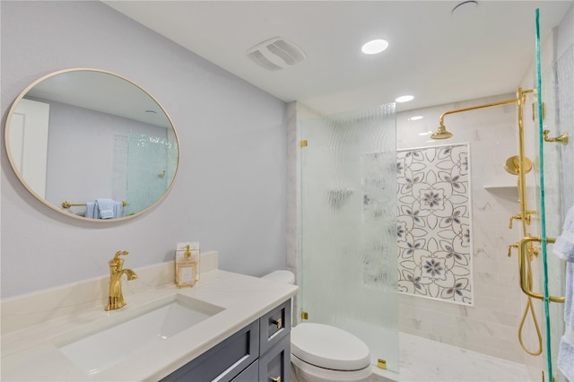 bathroom with toilet, vanity, and tiled shower