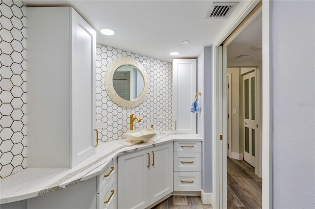 bathroom featuring vanity, backsplash, and wood-type flooring