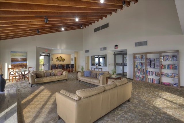 living room featuring beam ceiling and a high ceiling