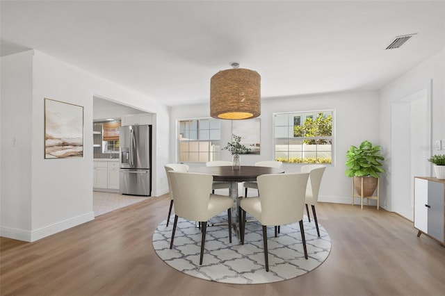 dining area featuring light hardwood / wood-style flooring and crown molding