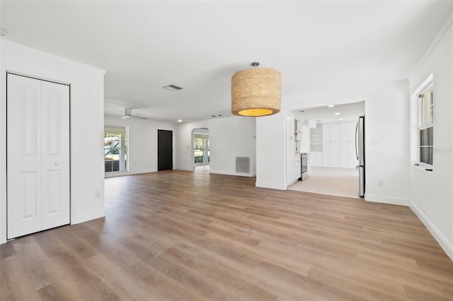 unfurnished living room with crown molding and light hardwood / wood-style floors