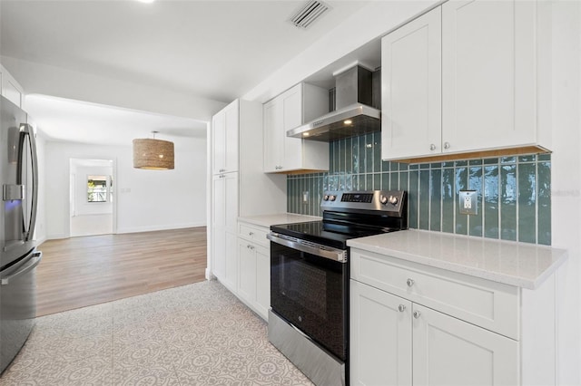 kitchen featuring wall chimney exhaust hood, light wood-type flooring, white cabinetry, and appliances with stainless steel finishes