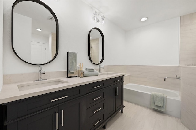 bathroom featuring a washtub and vanity