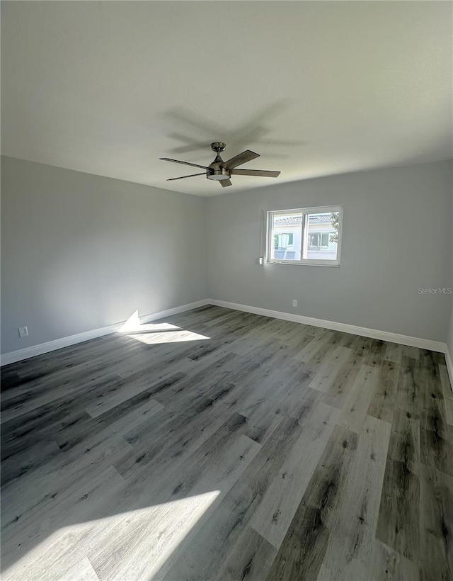 empty room with ceiling fan and wood-type flooring