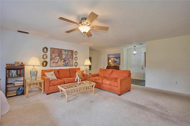 living room featuring light carpet, ceiling fan, and a textured ceiling