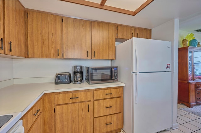 kitchen with light tile patterned floors and white refrigerator